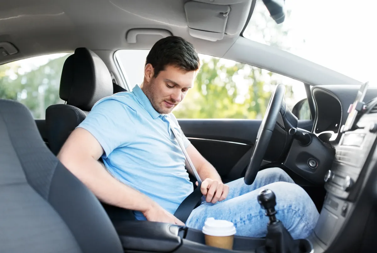 Vehicle interior with an occupant seated and the seat belt drawn across the body