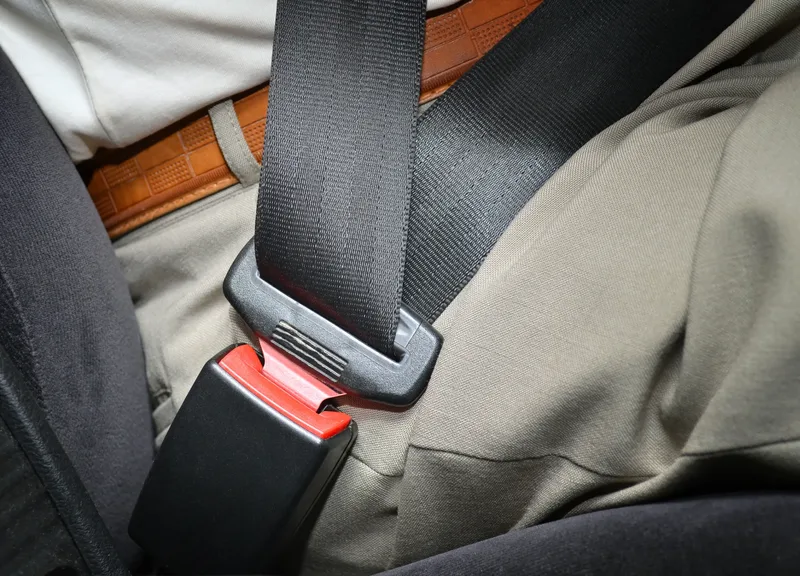 Fastened lap section of a seat belt across a seated occupant in a vehicle